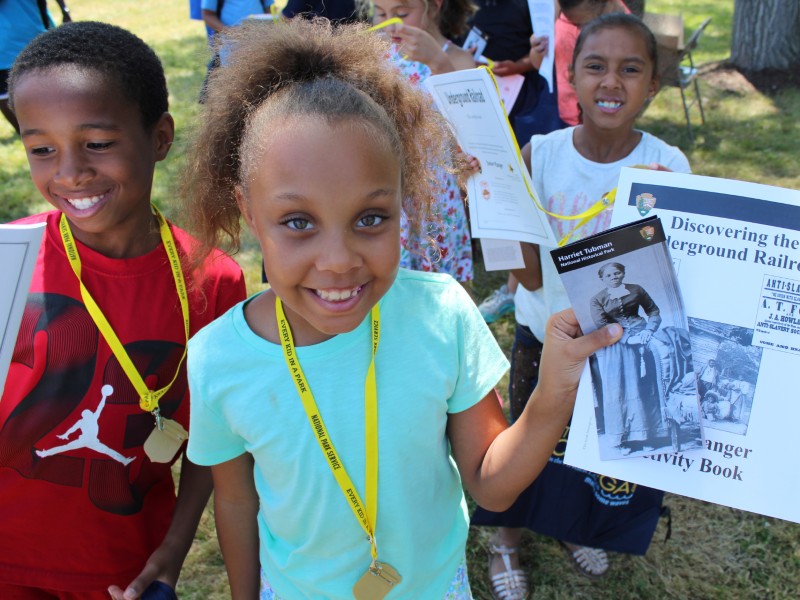 A student shows her junior ranger activity book at Harriet Tubman National Monument. Photo from NPS.