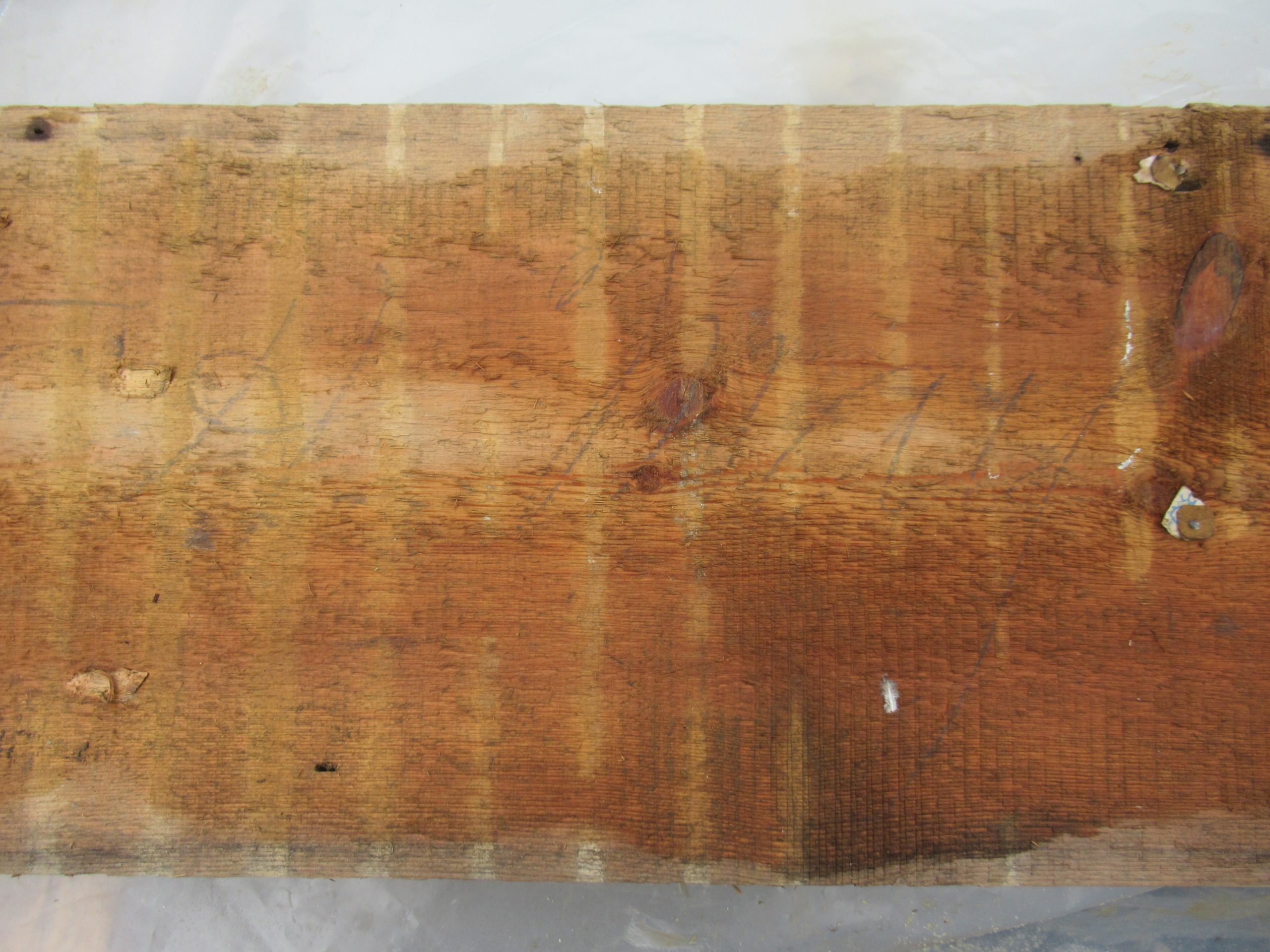 A piece of the cabin wall with faded cursive that read, “Sold to H May.”