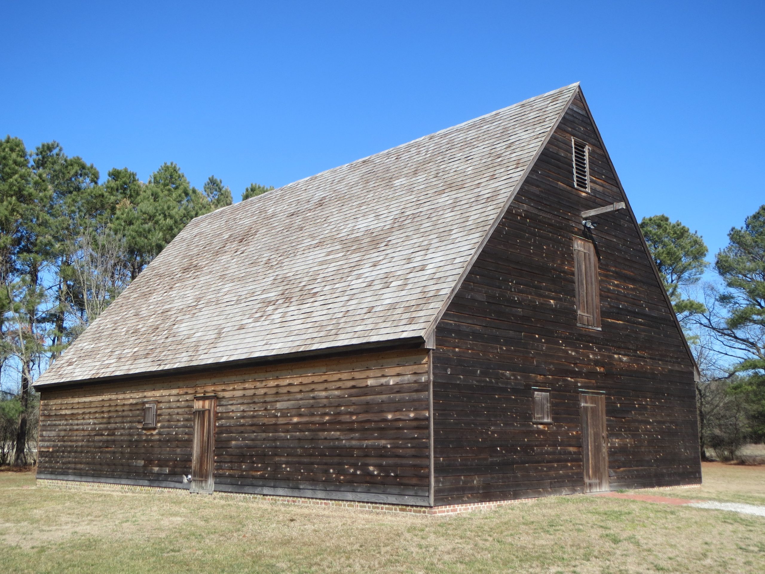 An image of a wooden farm building that is associated with Pemberton Hall, a home built in the mid-1700s. The buildings are now home to a museum and park.